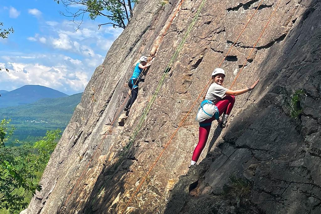 Two U N E students pose while rock climbing during a trailblazer pre-orientation trip