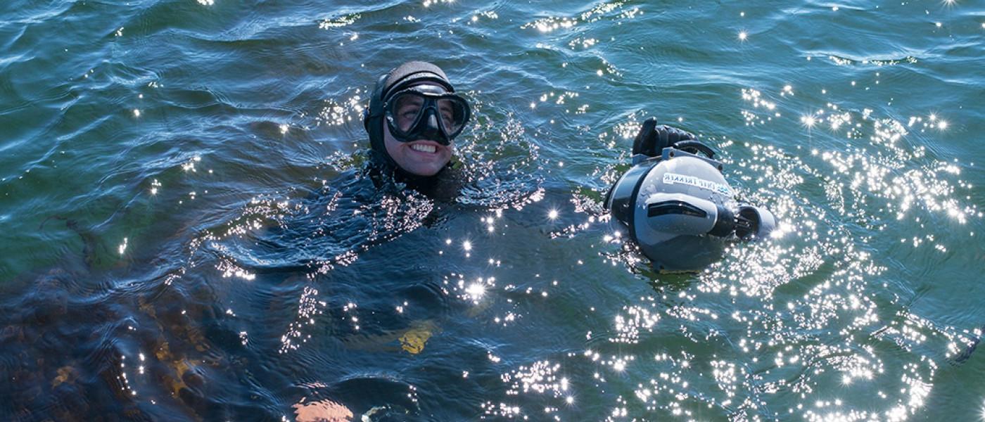 Two U N E students wear snorkeling equipment in the ocean